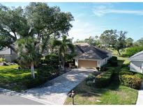 Single-story home with tile roof, driveway, and lush landscaping at 2213 Calusa Lakes Blvd, Nokomis, FL 34275