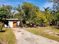 Ranch home with a spacious front yard, mature trees, and colorful landscaping at 3181 Irving St, Sarasota, FL 34237