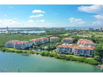 Stunning aerial view of a waterfront community with lush landscaping and a pool at 350 Gulf Of Mexico Dr # 211, Longboat Key, FL 34228