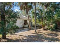 White house with brown shutters, surrounded by lush tropical landscaping at 608 N Jefferson Ave # 30, Sarasota, FL 34237