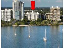 Aerial view of waterfront condo building with boats and city skyline in background at 707 S Gulfstream Ave # 604, Sarasota, FL 34236