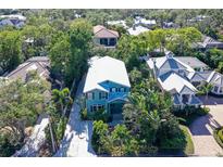 Aerial view of a teal house with a white roof, surrounded by lush tropical landscaping at 1732 Hillview St, Sarasota, FL 34239