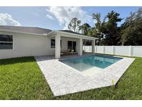 Beautiful backyard pool with patio and a well-maintained lawn, perfect for outdoor entertaining and relaxation at 1859 Lamont St, North Port, FL 34288