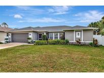Charming single-story home with a well-manicured lawn and colorful landscaping enhancing curb appeal at 6261 Keating Ave, North Port, FL 34291
