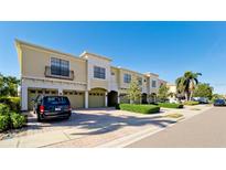 Tan three-story townhouses with attached garages, and lush landscaping at 4046 Overture Cir # 4046, Bradenton, FL 34209