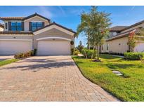 Brick paver driveway, lush landscaping, and two-car garage at 6035 Worsham Ln # 104, Lakewood Ranch, FL 34211