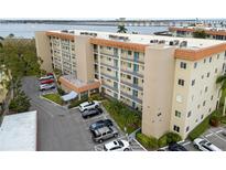 Aerial view of waterfront condo building with parking and tennis courts at 1650 1St W Ave # 302B, Bradenton, FL 34205