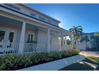 Inviting two-story home featuring a covered porch, white columns and lush landscaping at 1775 Stapleton St, Sarasota, FL 34239