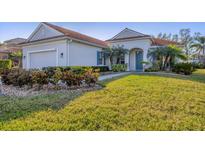Charming single-story home featuring lush landscaping, a colorful front door, and a well-maintained lawn at 4518 62Nd E Ter, Bradenton, FL 34203