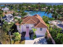 Aerial view of waterfront home with canal access, lush landscaping, and a private dock at 508 Siesta Dr, Sarasota, FL 34242