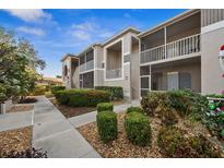 Exterior view of condo building with landscaped grounds and walkway at 9611 Castle Point Dr # 912, Sarasota, FL 34238