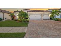 Charming home featuring a three-car garage, brick driveway and meticulous landscaping at 20717 Benissimo Dr, Venice, FL 34293