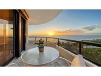 Oceanfront balcony with sunset view, table, chairs, and potted plant at 435 L Ambiance Dr # M408, Longboat Key, FL 34228