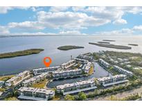 Aerial view of waterfront condo community with lush landscaping and private boat docks at 4430 Exeter Dr # M108, Longboat Key, FL 34228