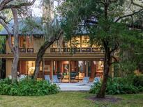 Backyard patio of a two-story home with lush landscaping and large windows at 3348 Old Oak Dr, Sarasota, FL 34239
