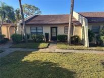 Exterior view of a Spanish-style home with a tiled roof and landscaping at 3645 Longmeadow # 31, Sarasota, FL 34235