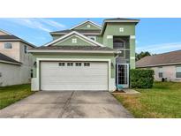 Two-story green house with a white garage door and well-manicured lawn at 4167 Day Bridge Pl, Ellenton, FL 34222