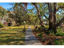 Paved pathway winds through lush landscaping, offering a serene community view at 425 30Th W Ave # C107, Bradenton, FL 34205