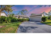 Attractive exterior featuring a two-car garage and lush landscaping at 4419 Glebe Farm Rd # 149, Sarasota, FL 34235