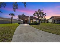 Charming home with a well-manicured lawn and a spacious driveway under a colorful evening sky at 5111 26Th St. Ct, W # 53, Bradenton, FL 34207