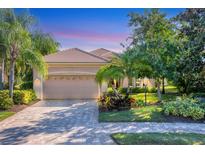 Beautiful home with a well-manicured lawn and a paved driveway at 7443 Riviera Cv, Lakewood Ranch, FL 34202