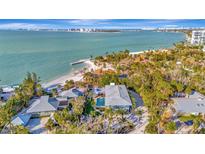 Breathtaking aerial view of coastal home with private beach access and stunning ocean views at 77 Sandy Hook N Rd, Sarasota, FL 34242