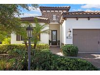 Two-story house with a tile roof, stone accents, and a two-car garage at 13126 Indigo Way, Bradenton, FL 34211