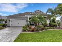 Charming single-story home featuring a two-car garage, landscaped yard, and a paver driveway at 13789 Old Creek Ct, Parrish, FL 34219