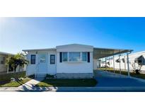 White single-wide mobile home with carport and landscaped yard at 3334 Overcup Oak Ter, Sarasota, FL 34237