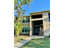 Exterior view of condo building with landscaping and walkway at 4009 Crockers Lake Blvd # 26, Sarasota, FL 34238