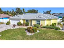 Bright yellow house with gray roof, white garage door, and landscaped lawn at 4913 22Nd E Ct, Bradenton, FL 34203