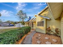 Charming yellow home with landscaped walkway, flowering bushes, and a well-maintained green lawn at 5101 Island Date St, Sarasota, FL 34232