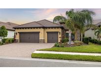 Beautiful two-story home with a three-car garage and a manicured lawn at 224 Corelli Dr, Nokomis, FL 34275