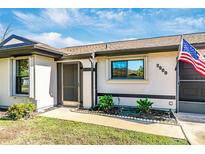 Inviting front entry with a covered porch and well-maintained landscaping at 3988 Abbotsford St, North Port, FL 34287