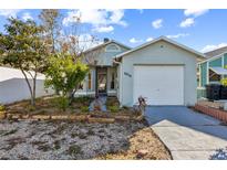 Charming single-story home with a brick and painted facade, attached garage, and landscaped front yard at 6614 Orange Blossom Trl, New Port Richey, FL 34653