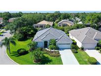 Single-story home with gray tile roof and lush landscaping at 8334 Sailing Loop, Lakewood Ranch, FL 34202