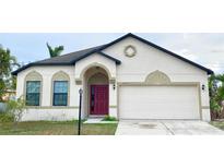 Charming single-story home with a red front door and attached two-car garage at 1415 22Nd E St, Palmetto, FL 34221