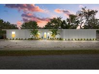 Charming single-story home with a bright white exterior, well-manicured lawn, and beautiful landscaping at 2069 Bougainvillea St, Sarasota, FL 34239