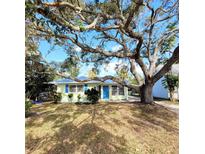 Charming light green home with blue shutters and large oak tree at 2253 Arlington St, Sarasota, FL 34239