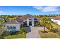 Luxury home with tile roof, palm trees, and a paved driveway at 8921 Artisan Way, Sarasota, FL 34240