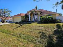 Yellow two-story home with a tiled roof, attached garage, and landscaped yard at 779 Nectar Rd, Venice, FL 34293