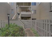 Private entrance to a condo with stairs leading to the second floor and lush landscaping at 109 Woodland Pl, Osprey, FL 34229