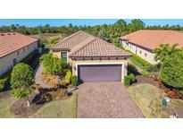 Attractive single-story home with a tile roof, paver driveway, and landscaped yard at 12667 Sorrento Way, Bradenton, FL 34211