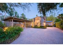 Charming home with a brick driveway, carport, and lush landscaping at dusk at 1656 Hillview St, Sarasota, FL 34239