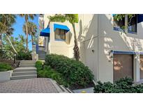 Unit exterior showcasing stairs, landscaping, and garage access at 1904 Harbourside Dr # 204, Longboat Key, FL 34228