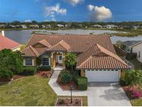 Attractive single-story home with tile roof, landscaped yard, and waterfront view at 4875 Wood Pointe Way, Sarasota, FL 34233