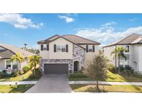 Two-story house with a two-car garage, stone accents and a tile roof at 4877 Antrim Dr, Sarasota, FL 34240