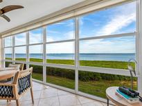 Bright sunroom with stunning water views and comfortable seating at 4900 Gulf Of Mexico Dr # 205, Longboat Key, FL 34228