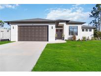 Charming single-story home with a two-car garage and landscaped front yard at 1256 Napoleon Rd, North Port, FL 34288