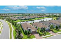 Aerial view of a beautiful home with a lake view in a well-maintained community at 4707 Arpino Ct, Bradenton, FL 34211